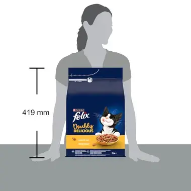 Balenie krmiva Felix Doubly Delicious 3 kg opreté o stôl vedľa siluety ženy, výška balenia je 419 mm.
